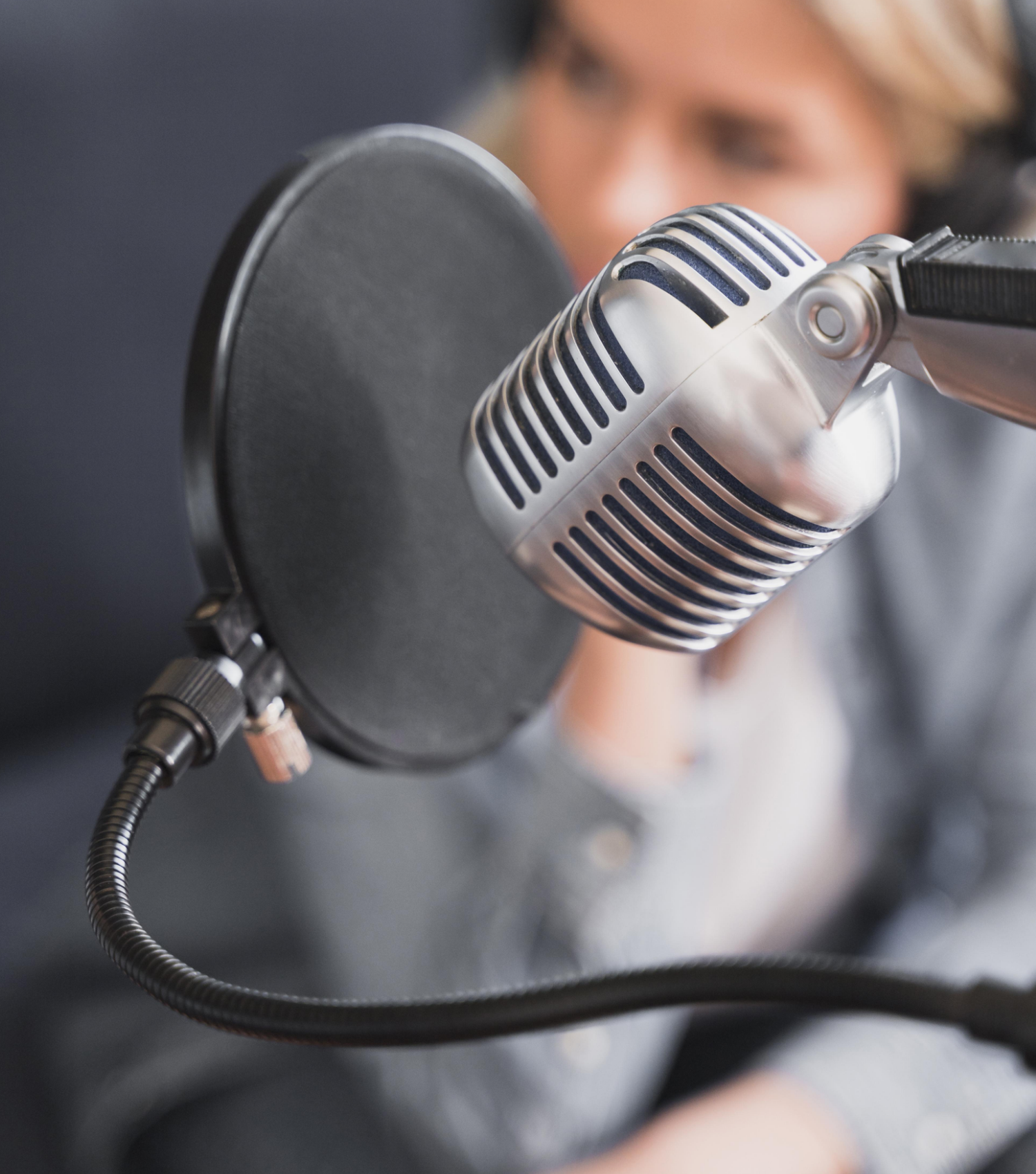 femme derrière micro de podcast, effet zoomé sur le micro
